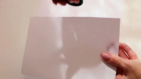 Woman's hands cutting an A4 paper into even squares. Stock Footage 319887404