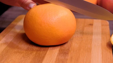 Woman's hands cutting fresh grapefruit on kitchen Video stock 123356170