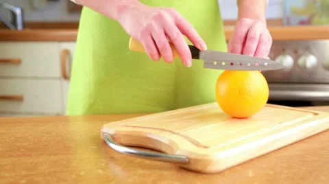 Woman's hands cutting orange Stock Footage