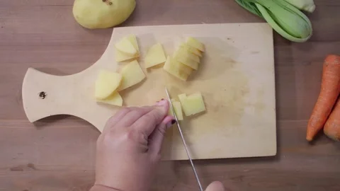 Woman's hands cutting potatoes on a cutting board Stock Footage 329684958