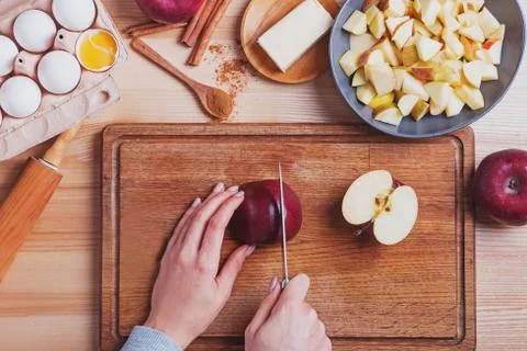 Woman's hands cutting red apple on the table Stock Photos