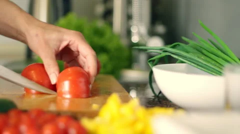 Woman's hands cutting tomato, behind fresh vegetables, pan shot Stock Footage 4053348