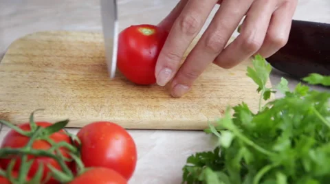 Woman's hands cutting tomato, behind fresh vegetables. Stock Footage 51674008