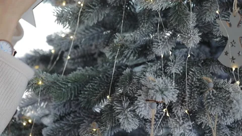 A woman's hands decorates a Christmas tree with toys, a wooden star Stock Footage 137966433