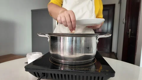 A womans hands dip a chicken fillet into a pot of boiling water, homemade broth. Stock Footage 319329994