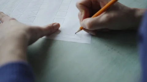 Woman's hands drawing on the white sheet of paper on the wood desk. 库存影片 104412325