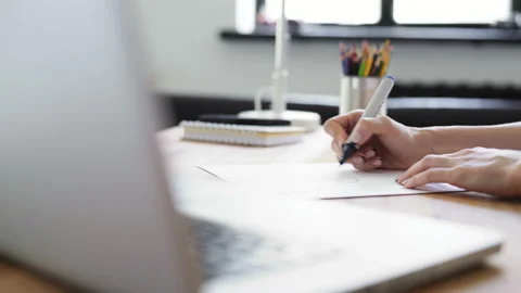 Woman's hands drawing on the white sheet of paper on the wood desk. Close up cre Stock Footage 199491297