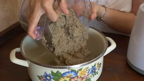 Woman's hands emptying meat pâté from a food processor into a pot Stock Footage 334320835