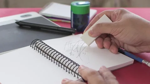 Woman's hands erasing notes written in pencil on a notebook Stock Footage 136270039