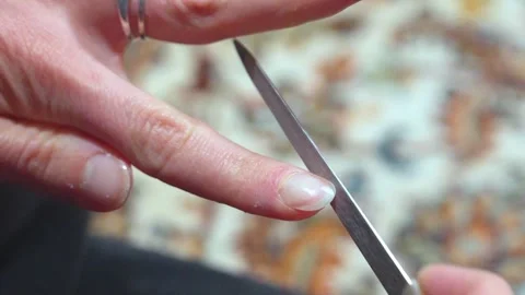 Woman's hands filing her nails on a carpet Stock Footage 307611708