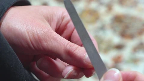 Woman's hands filing her nails on a carpet Video stock 307611795