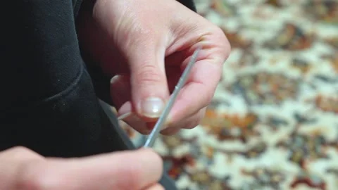 Woman's hands filing her nails on a carpet Video stock 307611845