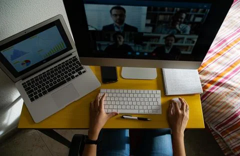 Woman's hands in front of computer with video conference. Stock Photos