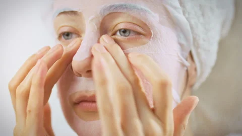 Womans hands gently spread a cooling aloe vera mask across her skin in front Stock Footage 346393438