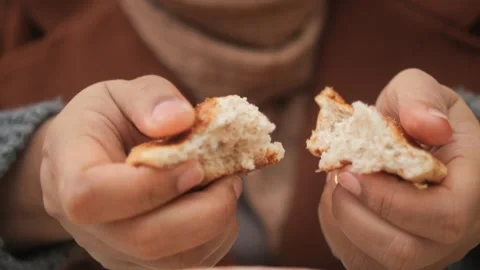 Woman's hands gently tear fresh baked bread, revealing soft texture in motion Stock Footage 332745527