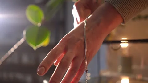 Woman's hands gently touching a delicate silver chain Stock Footage 328006595