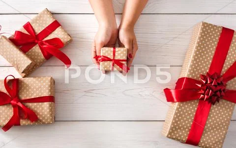 Woman's hands give christmas gift in present box Stock Photos