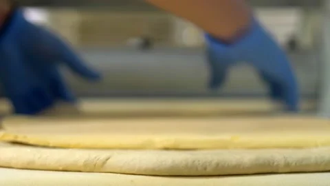 Woman's hands with gloves fold and shape the dough for bread Stock Footage 202610491