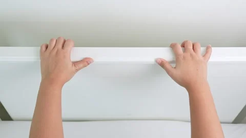 The woman’s hands grasp the bed’s headboard firmly. Stock Footage 316567954