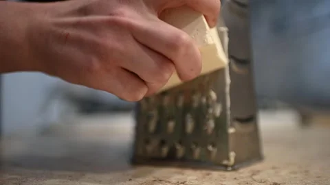 Woman's hands grating butter with a grater. Stock Footage 273738671
