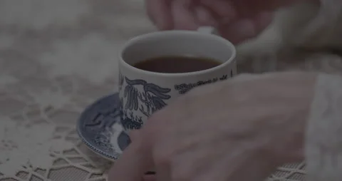 Woman's hands grip and drink Tea from a fine china cup and saucer Stock Footage 211447943