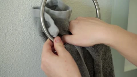 Woman's hands hanging gray towel on holder Stock Footage 329200344