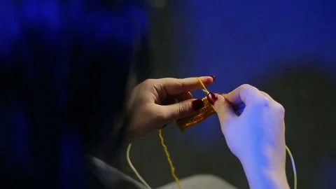 Woman's hands hold knitting needles and knit from yellow thread Stock Footage 103474149