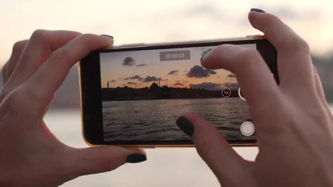 Woman's hands hold smartphone while shooting video Video stock 98358539