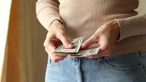 Woman's hands holding American dollar (USD) cash money banknotes. Stock Footage 303517697