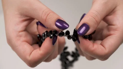 Woman's hands holding a beaded string with black and crystal beads Stock Footage 99048864