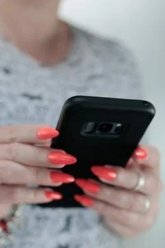 Woman's hands holding a black smartphone Stock Photos