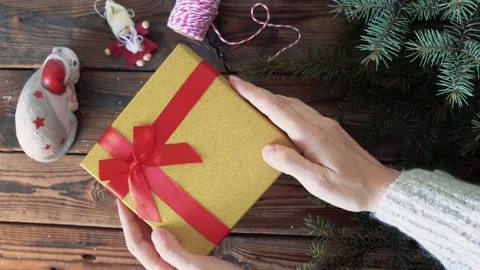 Woman's hands holding a box with a gift in her hands and shakes a box withgifts Stock Footage 140808787