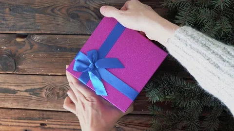 Woman's hands holding a box with a gift in her hands and opens a box Stock Footage 140808802