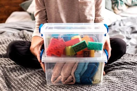 Woman's hands holding boxes with blocks and clothing. Stock Photos