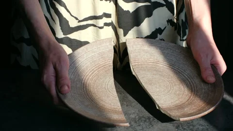 Woman's hands holding a broken ceramic plate Stock-Footage 337892544