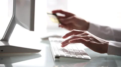 Woman's hands holding a credit card and using computer for online shopping Stock Footage