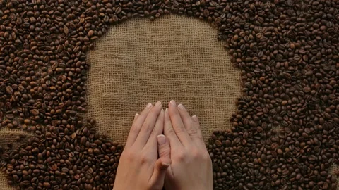 Woman's hands holding a heart shape coffee beans. Love of coffee concept Stock Footage 135657626