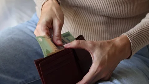 Woman's hands holding leather wallet with Vietnamese dong cash money banknotes. Stock Footage 303570916