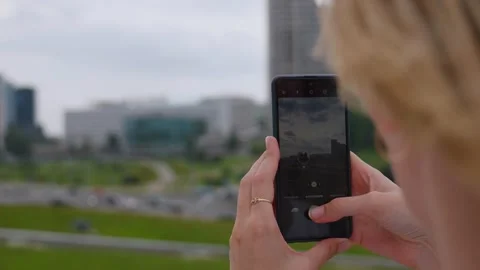 Woman's hands holding a smartphone taking a picture of a cityscape Stock Footage 324721050