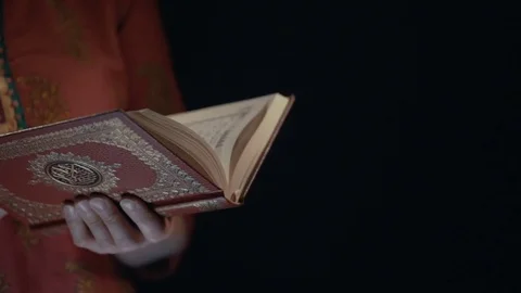 Woman's hands holds Koran - holy book of muslims Stock Footage 75697423