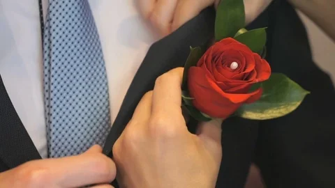 Woman's hands insert boutonniere in pocket Stock Footage
