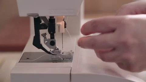 Woman's hands inserts a white thread into a white sewing machine Stock Footage 166879940