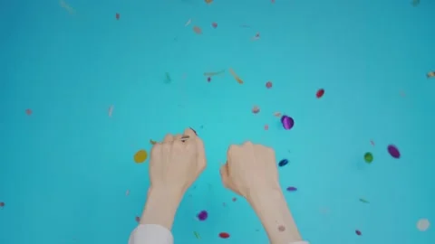Womans hands isolated on blue background with confetti falls. Woman raising Stock Footage 131061644