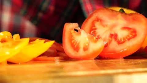 Woman's hands in kitchen cutting fresh tomato on wooden cutting board Stock-Footage 147935064