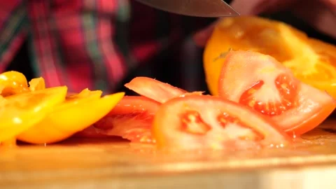 Woman's hands in kitchen cutting fresh tomato on wooden cutting board Stock-Footage 147935118