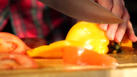 Woman's hands in kitchen cutting fresh tomato on wooden cutting board Stock-Footage 147935448