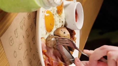 A woman's hands with a knife and fork cut sausages Stock Footage 263730103