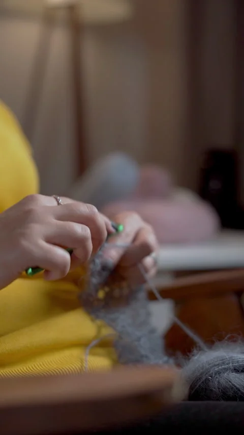 Of woman's hands knitting a woolen sweater. A woman knits from thin yarn Stock Footage 275592926