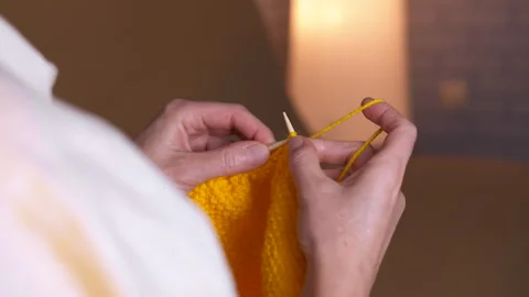 Woman's hands knitting yellow yarn close up. Stock Footage 327449769