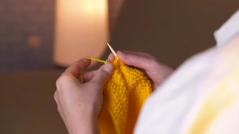 Woman's hands knitting with yellow yarn. Video stock 330680564
